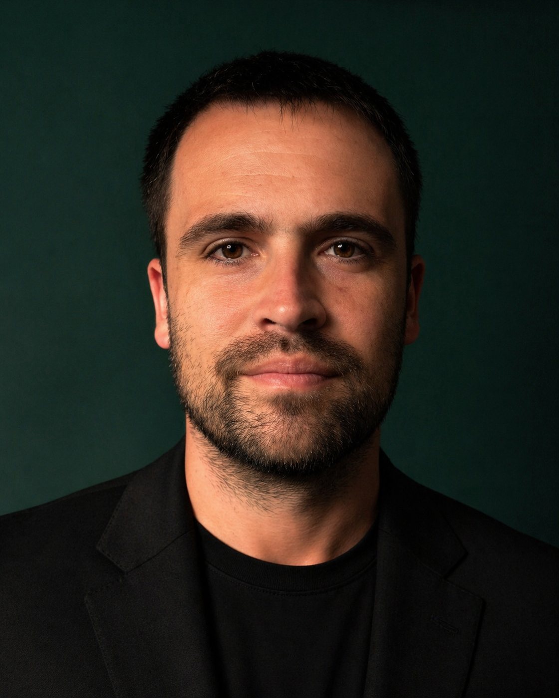 Retrato de Nathanael Estivalett, de blazer preto, em fundo verde escuro